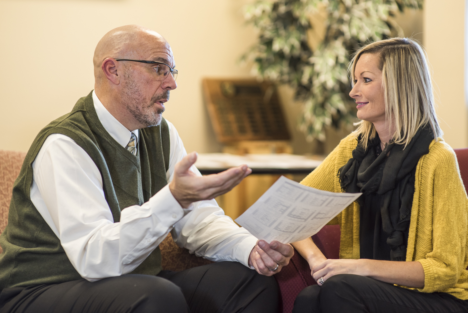 A man and woman chatting and reviewing a document.